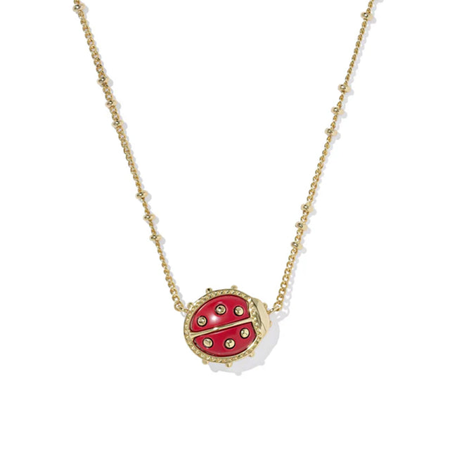 Red ladybug pendant necklace on a gold chain against a white background