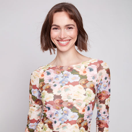 Woman wearing a floral dress against a plain background