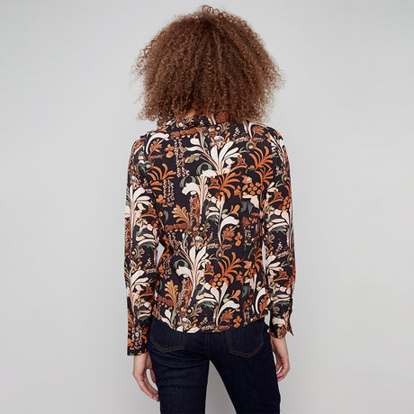 Person wearing a patterned shirt with a plain background