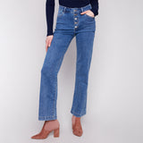 Person wearing blue jeans with a button fly on a white background