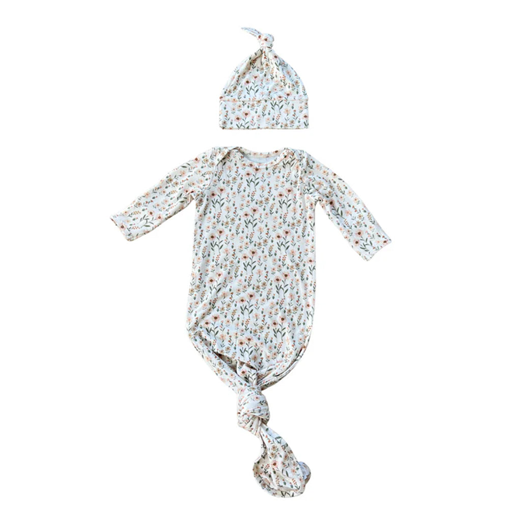 Baby outfit with floral patterned gown and hat on a white background