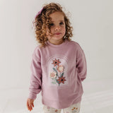 little girl in pink sweatshirt with flowers on front