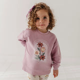 little girl in pink sweatshirt with flowers on front