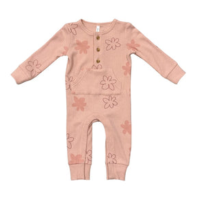 A baby's long-sleeve ribbed jumpsuit in a dusty pink color, decorated with a pattern of simple pink and brown flower outlines. It features a button-up front with three wooden buttons.