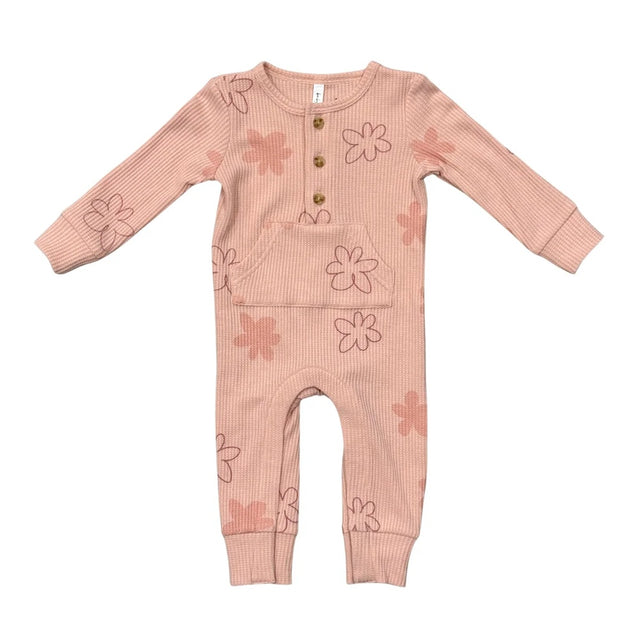 A baby's long-sleeve ribbed jumpsuit in a dusty pink color, decorated with a pattern of simple pink and brown flower outlines. It features a button-up front with three wooden buttons.