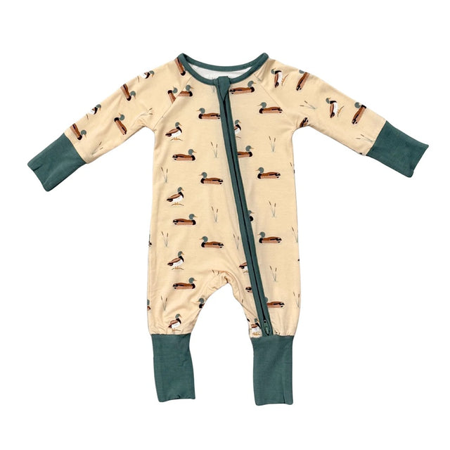 Baby onesie with duck pattern on a beige background