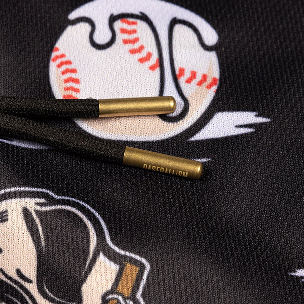 Close-up of black drawstring cords with gold-toned metal tips on a black hoodie featuring a baseball graphic.