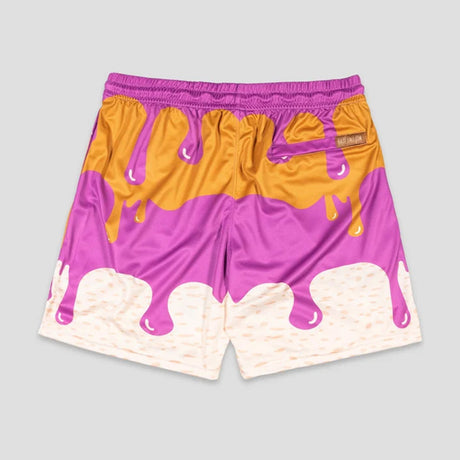 A pair of athletic shorts featuring a dripping chocolate sauce design in purple, orange, and cream, shown flat against a light gray background.