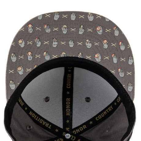 Close-up of the inside of a gray snapback cap with a repeating pattern of hand gestures and crossed X's, black mesh back panels, and black adjustable strap with gold text.