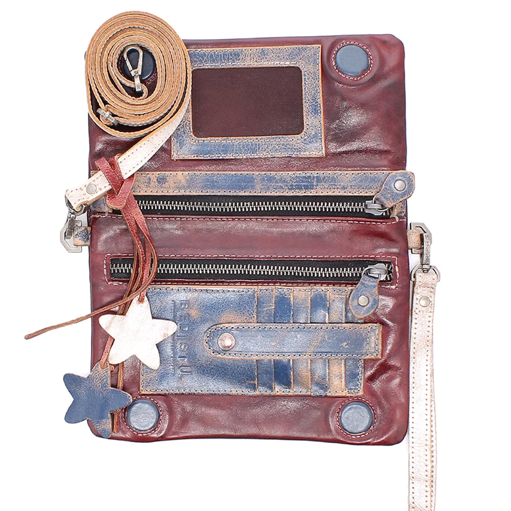 A distressed leather crossbody bag in reddish-brown with blue-toned weathered patches, multiple zip compartments, a rolled tan strap, and star-shaped charms on a plain white background.