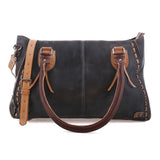 A dark charcoal gray leather shoulder bag with tan leather handles, trim, and a detachable shoulder strap, featuring decorative whipstitching along the edges.