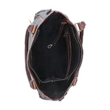 An overhead view of an open brown leather tote bag, showing a black fabric interior with zipper compartments and side strap attachments, set against a plain white background.