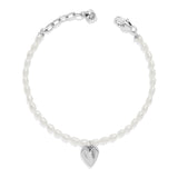 Silver bracelet with a heart charm on a white background
