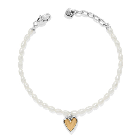 Pearl bracelet with a gold heart charm on a white background