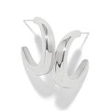 A pair of polished silver-toned hoop earrings with a modern, curved open design, displayed on a clean white background with soft shadows.