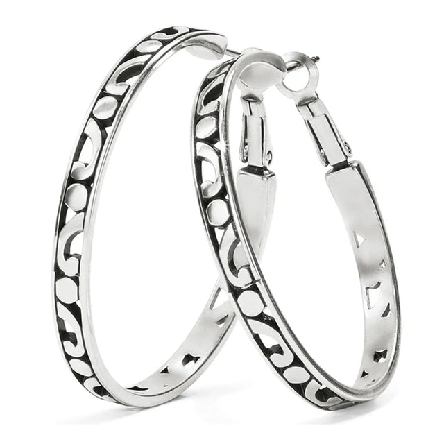 Pair of silver hoop earrings with intricate patterns on a white background