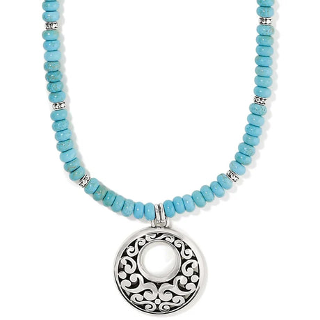 Turquoise beaded necklace with a silver pendant on a white background