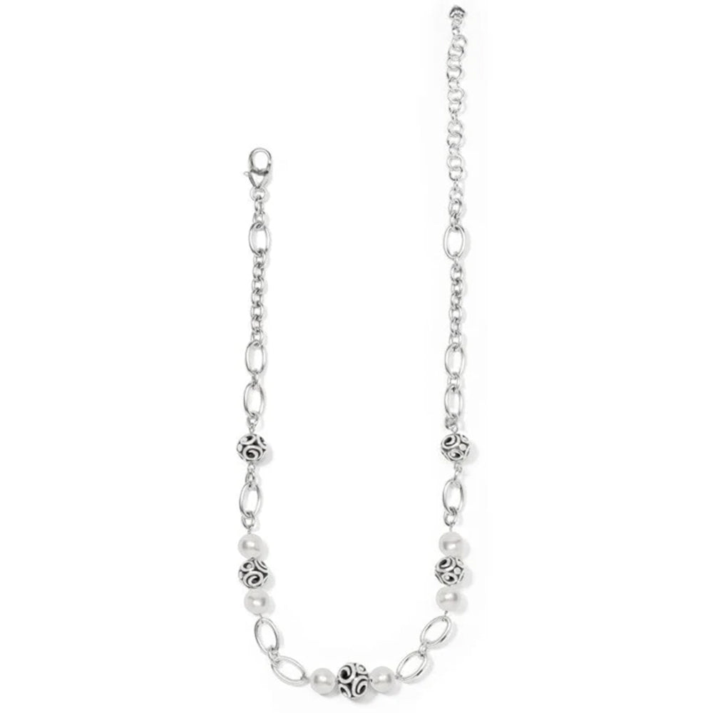 Silver chain necklace with white beads on a white background