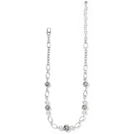 Silver chain necklace with white beads on a white background