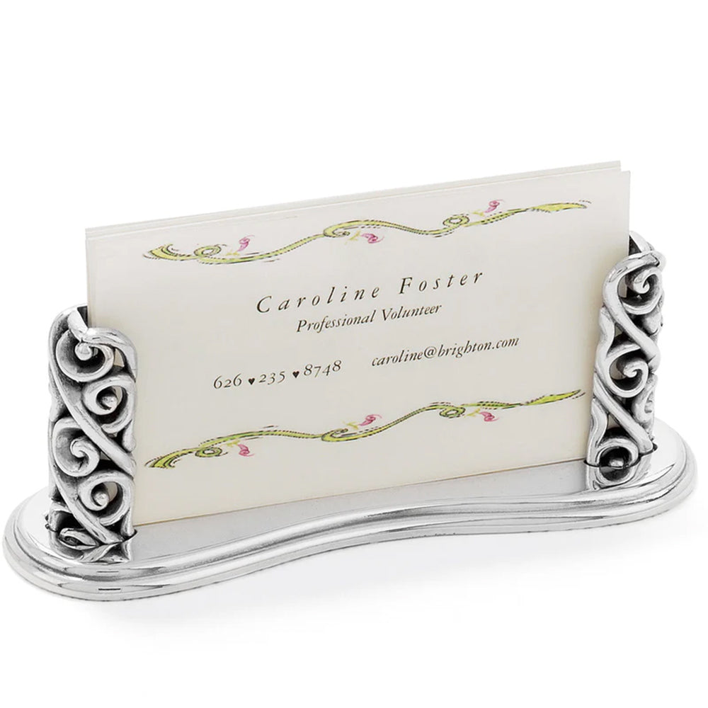 Decorative silver business card holder with a business card featuring the name Caroline Foster.