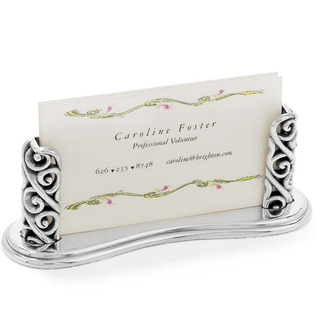 Decorative silver business card holder with a business card featuring the name Caroline Foster.