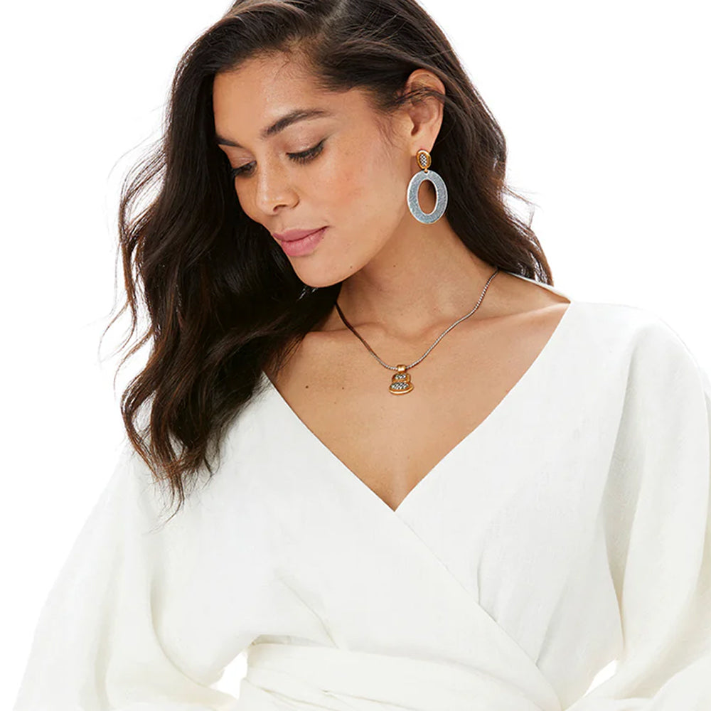 Woman wearing a white top with gold jewelry on a white background