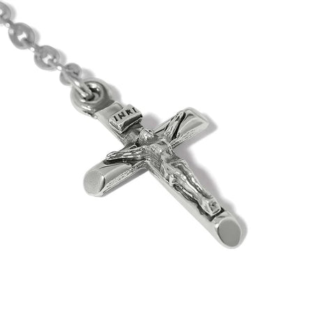 Silver crucifix pendant on a chain against a white background