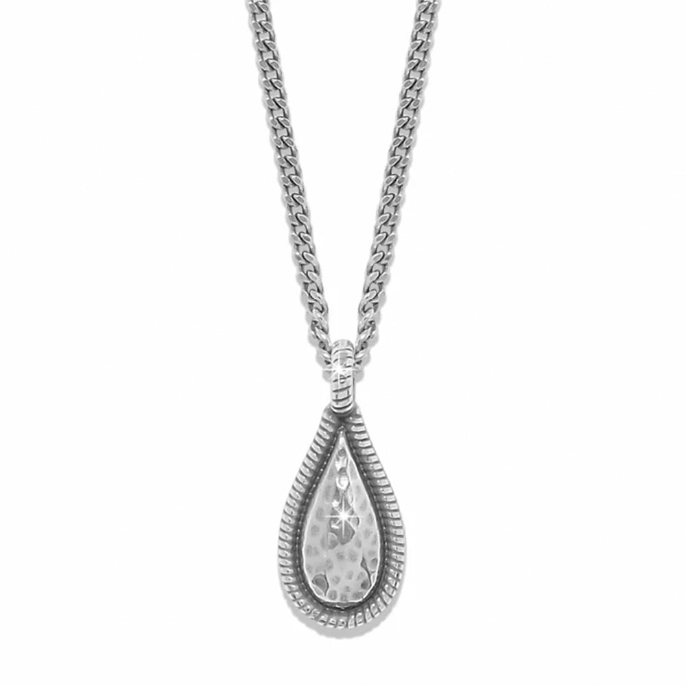A silver teardrop pendant necklace with a hammered center and a textured outer border, hanging from a silver curb chain against a plain white background.