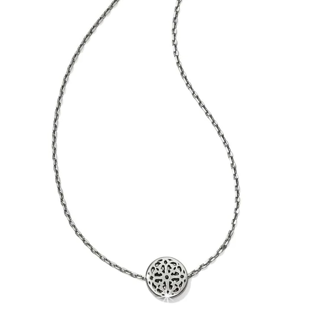 Silver necklace with a round, intricately designed pendant on a white background
