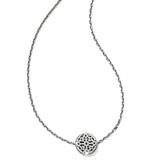 Silver necklace with a round, intricately designed pendant on a white background