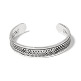 Silver bracelet with intricate design on a white background