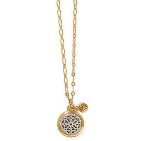 Gold necklace with a round pendant on a white background