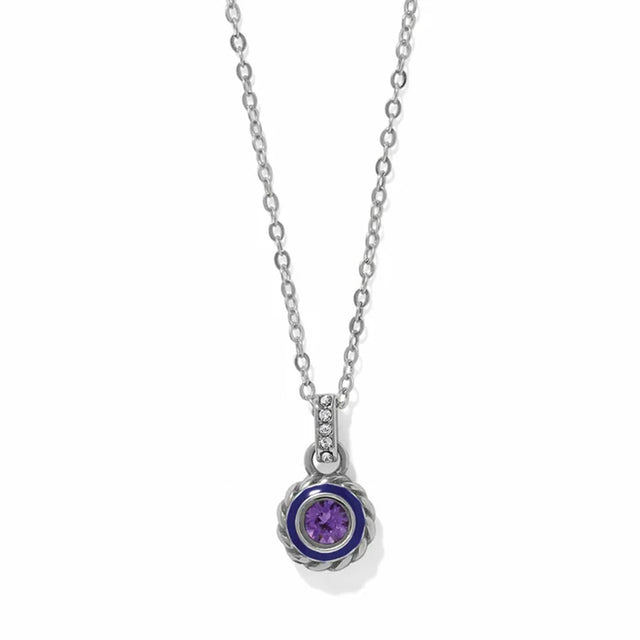 A silver chain necklace with a round pendant featuring a purple gemstone surrounded by a dark blue inlay and a textured silver border, shown on a white background.