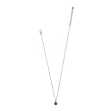 A delicate silver chain necklace with a small round dark purple gemstone pendant, displayed against a solid white background.