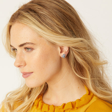 Close-up of a woman wearing earrings with a plain background