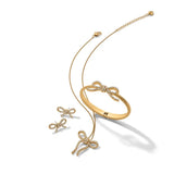 Gold bow-shaped jewelry set on a white background