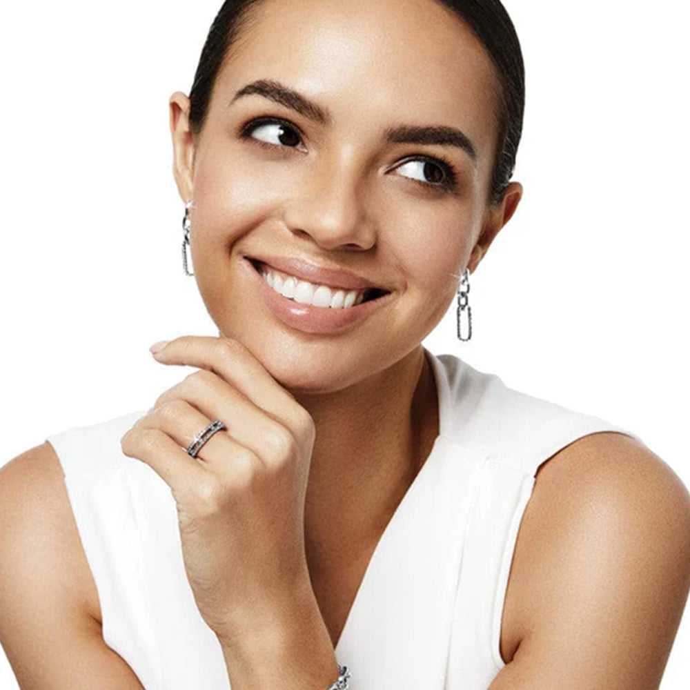 Woman wearing a white sleeveless top with a plain background