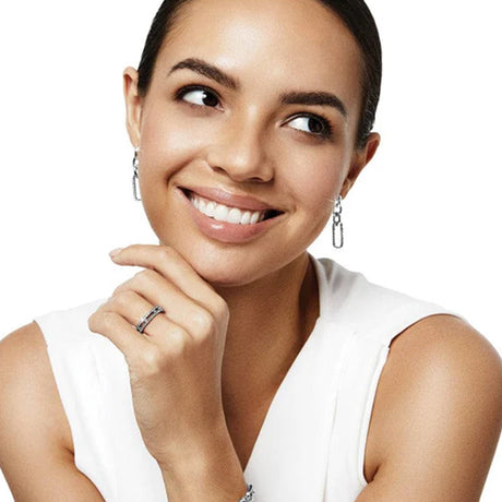 Woman wearing a white sleeveless top with a plain background