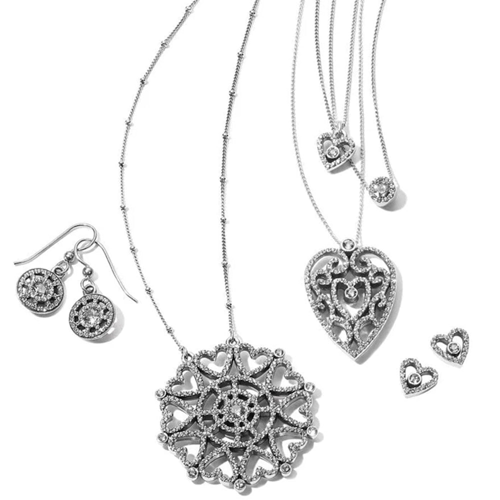 Silver jewelry set with necklaces, heart-shaped pendants, and earrings on a white background