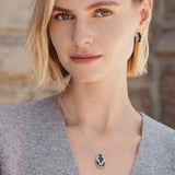 Woman wearing a silver necklace with a pendant against a blurred background