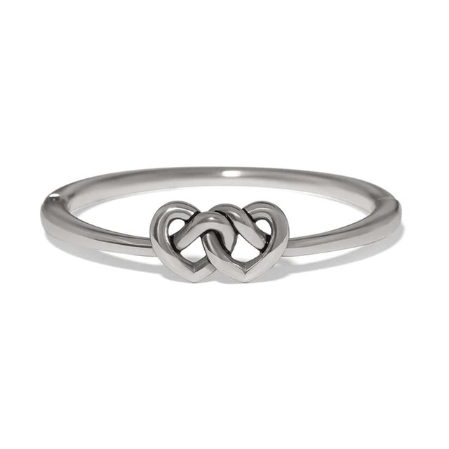 A polished silver ring featuring a central interlocking double heart design, shown on a clean white background.