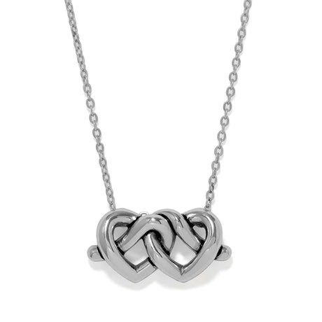 A silver necklace featuring a polished pendant made of two interlocking hearts, suspended from a delicate silver chain against a plain white background.