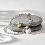 Bracelet with heart-shaped charms on a stone surface
