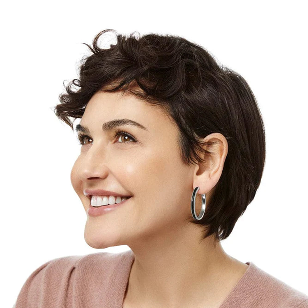 Woman with short, styled hair wearing a pink top on a white background
