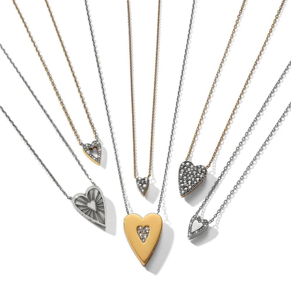 Set of heart-shaped pendants on gold and silver chains against a white background