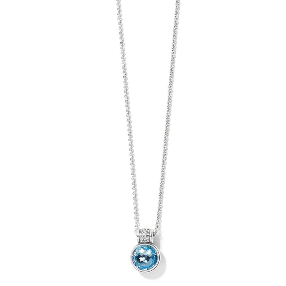 A silver-toned necklace featuring a round bezel-set light blue gemstone pendant, displayed against a clean white background.