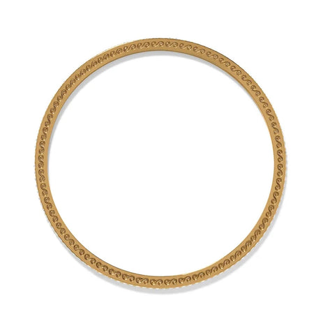 Gold bangle with intricate design on a white background