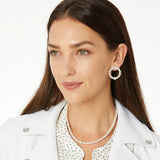 Woman wearing pearl earrings and necklace on a white background