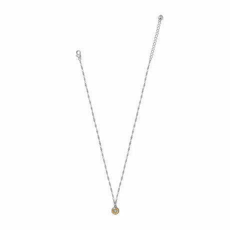 A delicate silver chain necklace with a small circular gold pendant featuring a central clear stone, displayed on a solid white background.