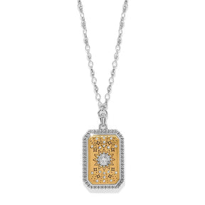 A silver-tone chain necklace with a rectangular pendant featuring a gold-tone center, a silver-tone sun motif, and rows of small clear stones around the border, shown on a white background.